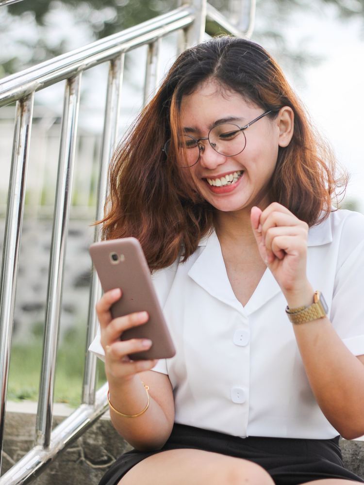 A girl holding her phone and looking at the screen