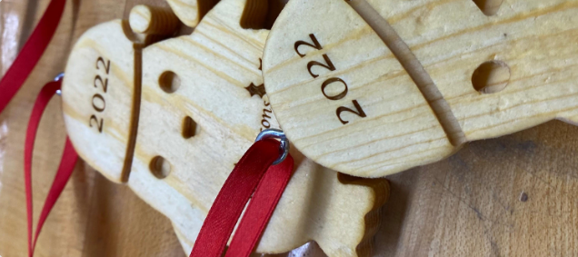 wooden Christmas ornaments in the shape of penguins with 2022 etched into them