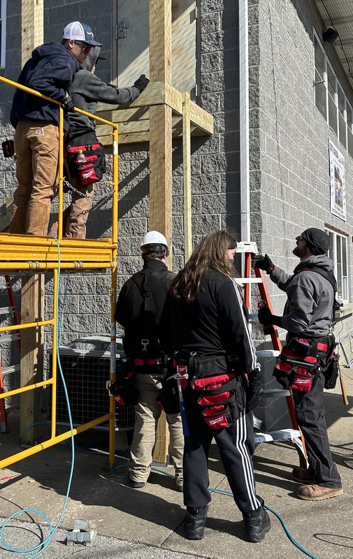 students standing on scaffolding